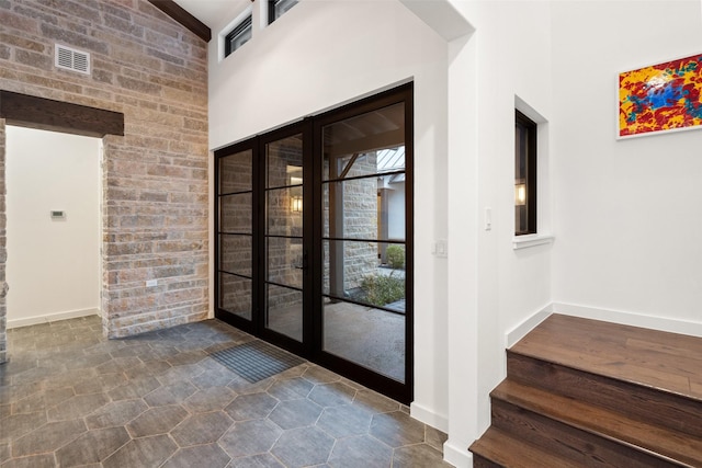 entryway featuring high vaulted ceiling and french doors