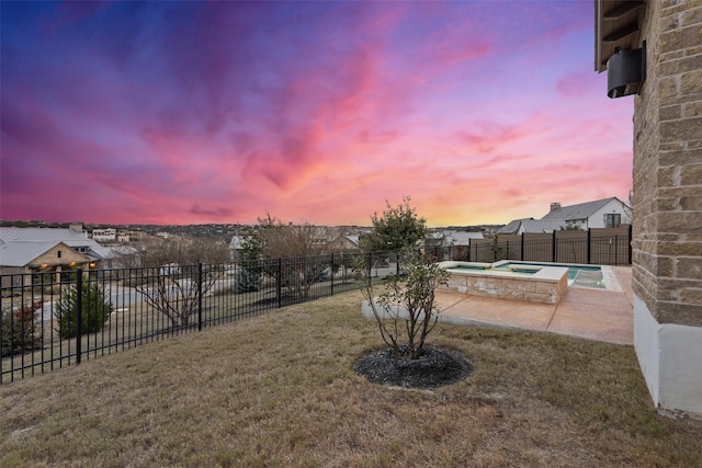 yard at dusk with an in ground hot tub