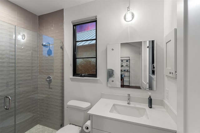 bathroom featuring toilet, a shower with shower door, and vanity