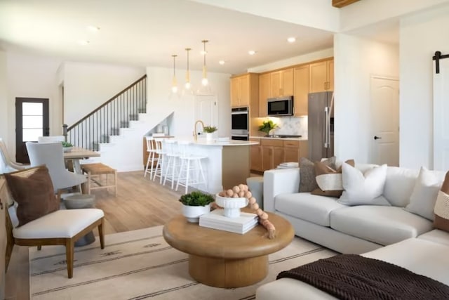 living room with light hardwood / wood-style floors and a barn door