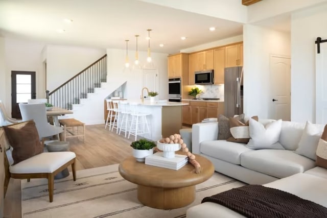 6204 Bower Well Rd, Austin, TX 78738 - living room with a barn door, stairs, light wood-type flooring, and recessed lighting