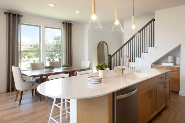 6204 Bower Well Rd, Austin, TX 78738 - kitchen with a sink, stainless steel dishwasher, light wood-style floors, light countertops, and an island with sink