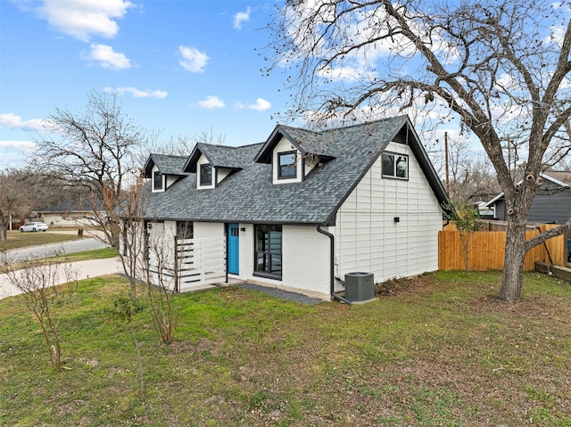 new england style home featuring central AC unit and a front lawn