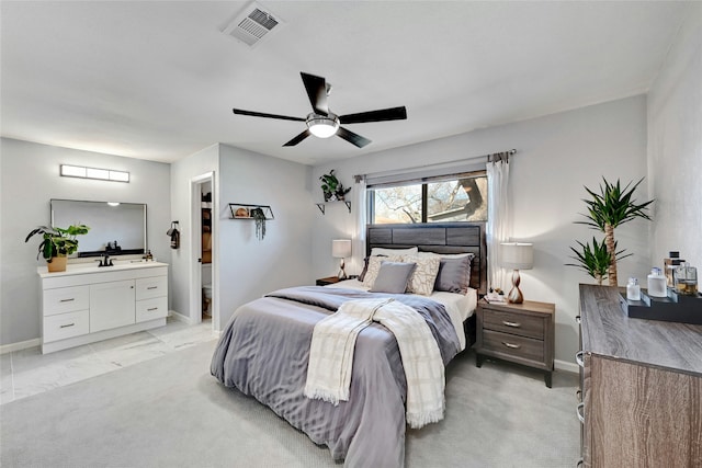 carpeted bedroom featuring ceiling fan and ensuite bath