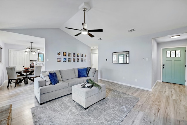 living room featuring light wood-type flooring, vaulted ceiling, and ceiling fan with notable chandelier