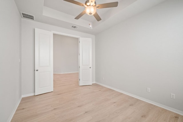 305 Five Mile Creek Way, Kyle, TX 78640 - spare room featuring a tray ceiling, a ceiling fan, light wood-style floors, and baseboards