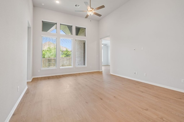 305 Five Mile Creek Way, Kyle, TX 78640 - spare room with a ceiling fan, baseboards, light wood-style flooring, and a high ceiling
