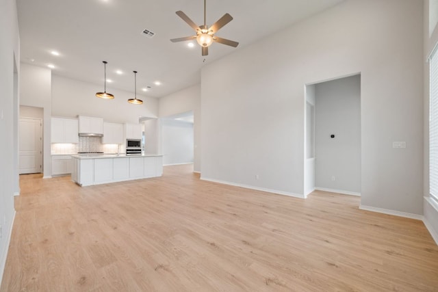 305 Five Mile Creek Way, Kyle, TX 78640 - unfurnished living room with high vaulted ceiling, a ceiling fan, light wood finished floors, baseboards, and recessed lighting