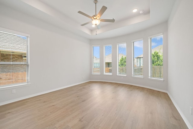 305 Five Mile Creek Way, Kyle, TX 78640 - empty room featuring light wood-type flooring, plenty of natural light, a raised ceiling, baseboards, and recessed lighting