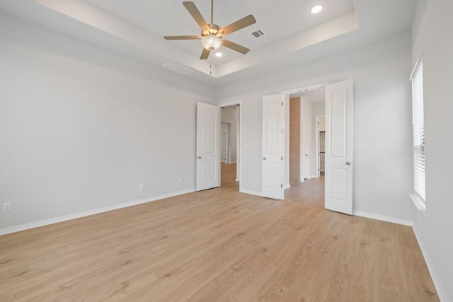 305 Five Mile Creek Way, Kyle, TX 78640 - unfurnished bedroom with light wood-type flooring, baseboards, a raised ceiling, recessed lighting, and a ceiling fan