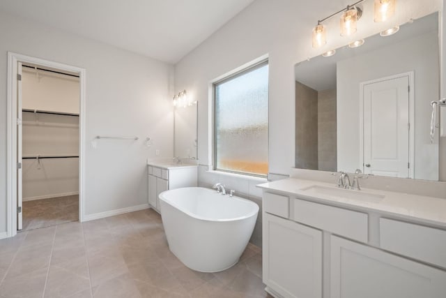 305 Five Mile Creek Way, Kyle, TX 78640 - full bath featuring two vanities, a soaking tub, a walk in closet, and baseboards