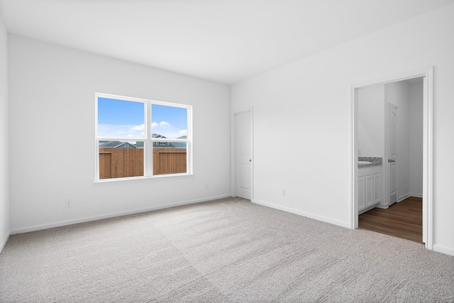 unfurnished bedroom featuring carpet flooring and ensuite bath