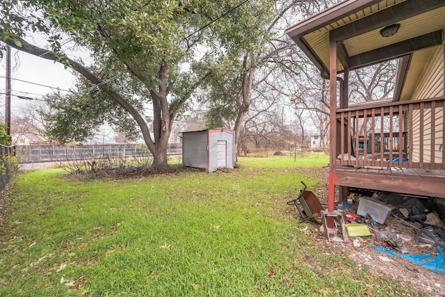 view of yard with a wooden deck and a storage shed