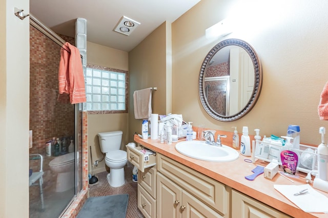 bathroom with toilet, tile patterned floors, a shower with shower door, and vanity