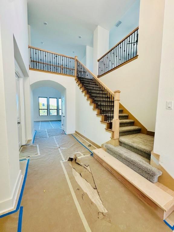 staircase featuring a towering ceiling