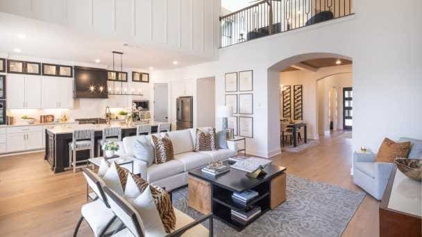 living room featuring light wood-type flooring and a towering ceiling