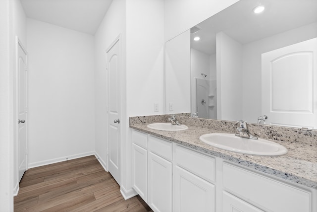 bathroom with vanity, a shower, and hardwood / wood-style flooring