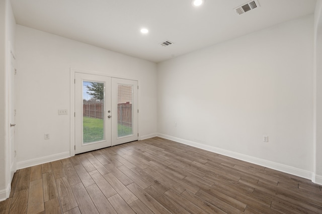 empty room featuring french doors and hardwood / wood-style floors