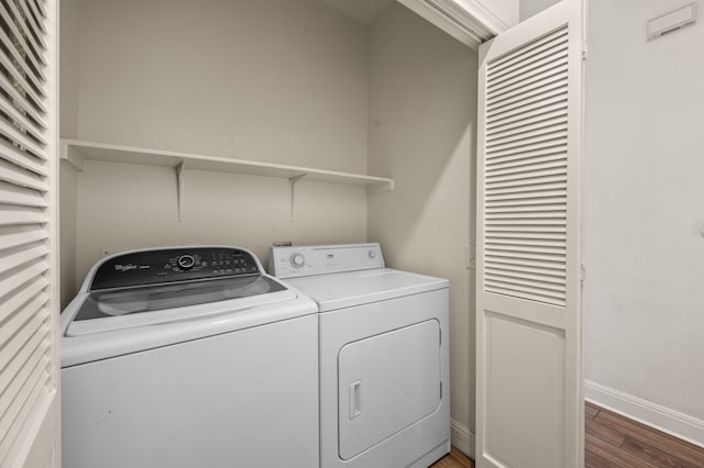 laundry room with dark wood-type flooring and independent washer and dryer