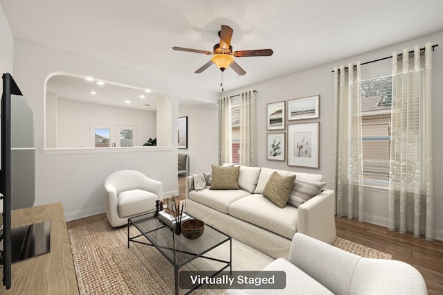 living room featuring ceiling fan, wood-type flooring, and a healthy amount of sunlight