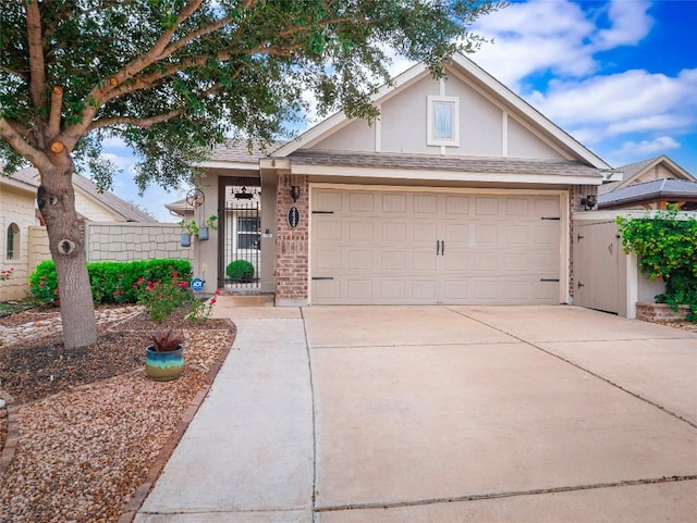 238 Rock Bluff Ln, San Marcos, TX 78666 - view of front facade featuring concrete driveway, a garage, fence, brick siding, and stucco siding