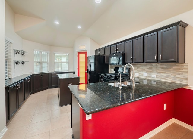 kitchen with tasteful backsplash, vaulted ceiling, dark stone countertops, a center island, and black appliances