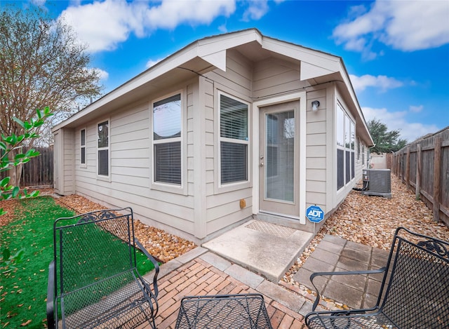 back of house featuring cooling unit, a yard, and a patio