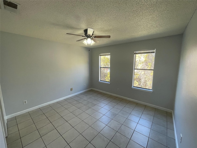 tiled empty room featuring ceiling fan and a textured ceiling