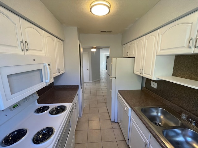 kitchen with decorative backsplash, sink, light tile patterned floors, white appliances, and white cabinets