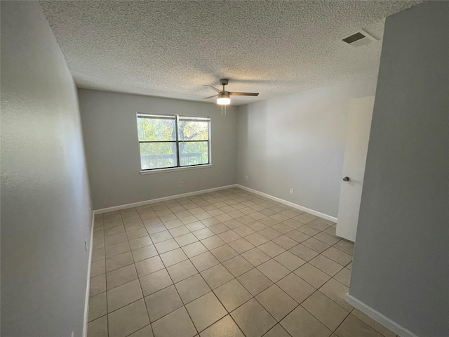 spare room with a textured ceiling, ceiling fan, and light tile patterned flooring