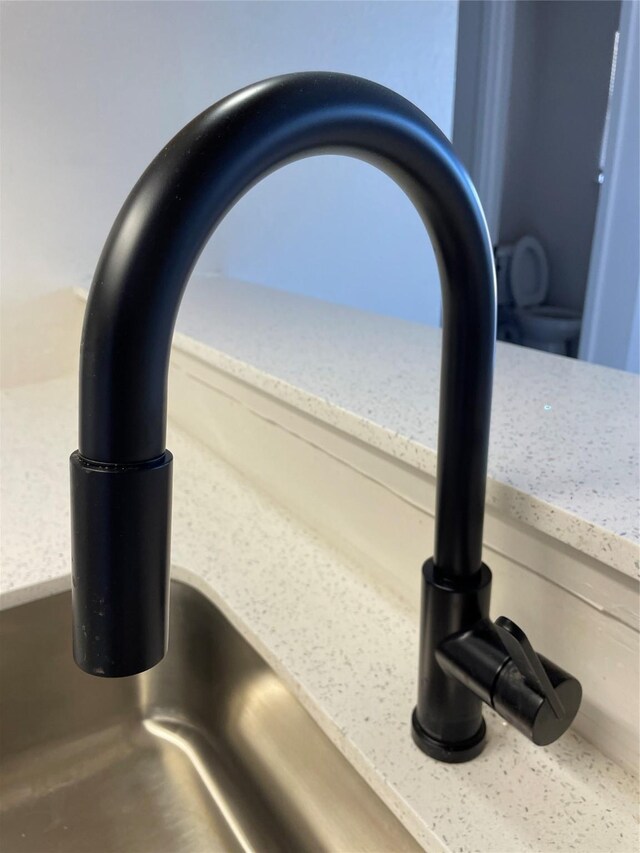 interior details featuring light stone countertops, a view of the beach, and sink