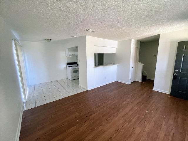 unfurnished living room featuring a textured ceiling and light hardwood / wood-style floors