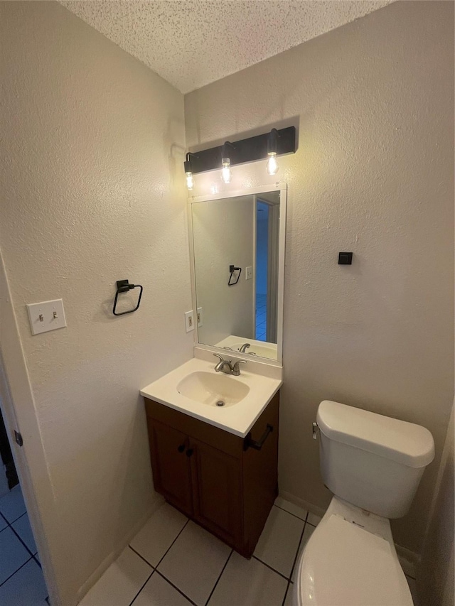 bathroom featuring a textured ceiling, toilet, tile patterned flooring, and vanity