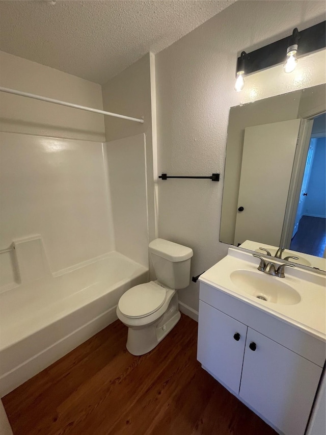 full bathroom with a textured ceiling, wood-type flooring, vanity, toilet, and shower / bathtub combination