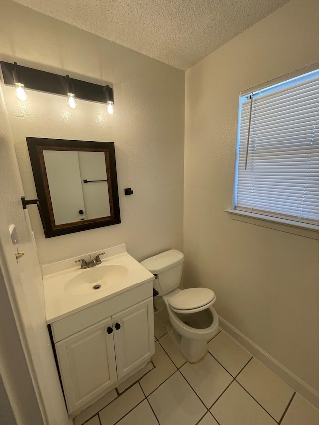 bathroom featuring a textured ceiling, toilet, vanity, and tile patterned flooring