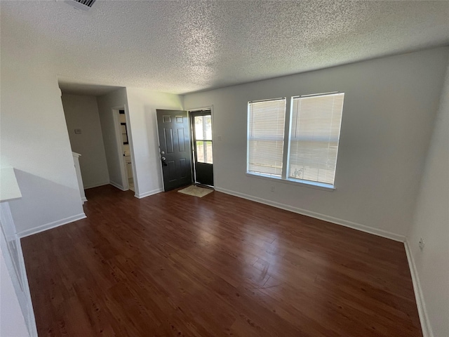 interior space with a textured ceiling and dark hardwood / wood-style flooring