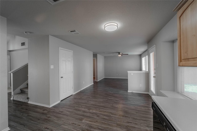 interior space with ceiling fan, dark wood-type flooring, and a textured ceiling