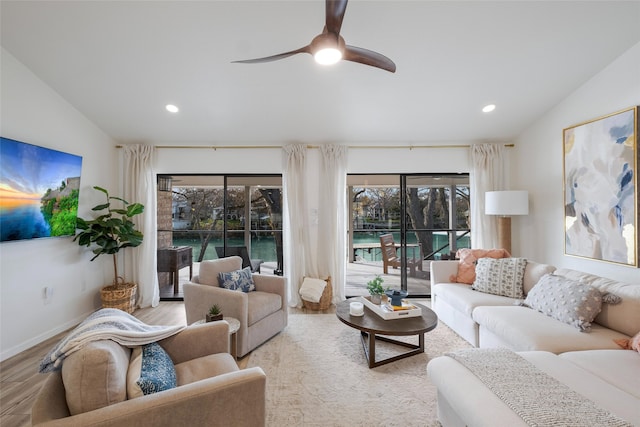 living room featuring vaulted ceiling, ceiling fan, and light hardwood / wood-style floors