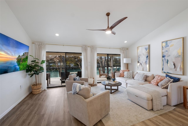 living room with ceiling fan, hardwood / wood-style floors, and vaulted ceiling