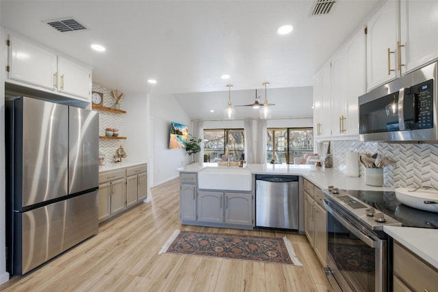 150 Turtle Ln, Seguin, TX 78155 - kitchen with stainless steel appliances, a sink, a peninsula, backsplash, and white cabinets