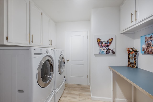 washroom featuring washer and dryer, cabinets, and light hardwood / wood-style flooring