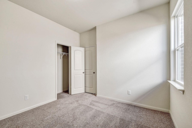 unfurnished bedroom featuring a closet and light carpet