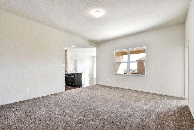 unfurnished room featuring dark colored carpet