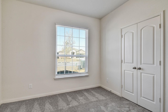 unfurnished bedroom featuring light carpet and a closet