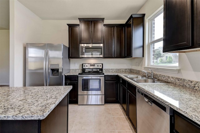 kitchen featuring sink, light tile patterned flooring, light stone counters, and stainless steel appliances