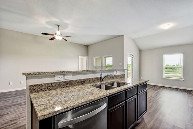 kitchen featuring light stone counters, sink, dishwasher, and an island with sink