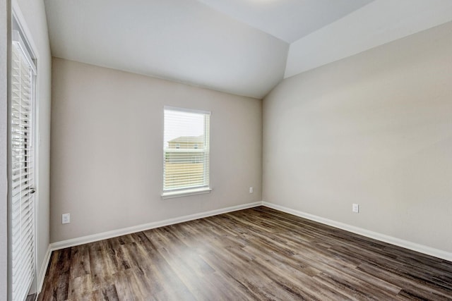 empty room featuring dark hardwood / wood-style floors and vaulted ceiling