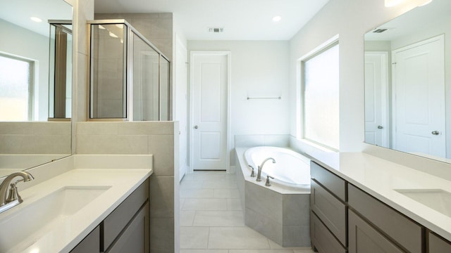 117 White Creek Ln, Georgetown, TX 78628 - full bathroom featuring healthy amount of natural light, two vanities, a stall shower, a garden tub, and recessed lighting