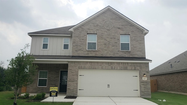 view of front of property featuring a front yard and a garage