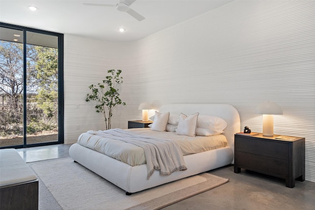 bedroom featuring ceiling fan, a wall of windows, access to exterior, and concrete floors